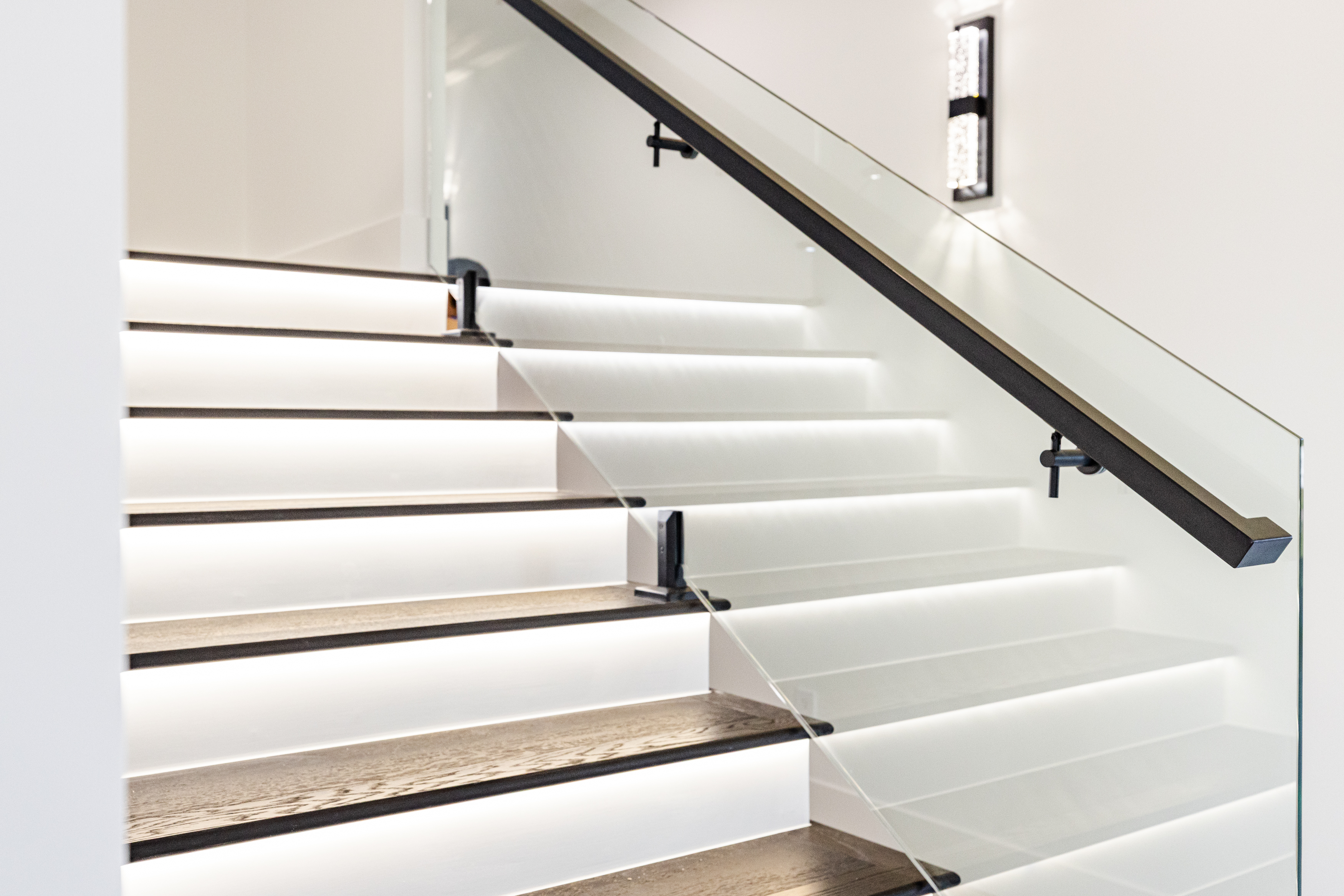 Close-up of custom LED stair lighting and illuminated wall sconces