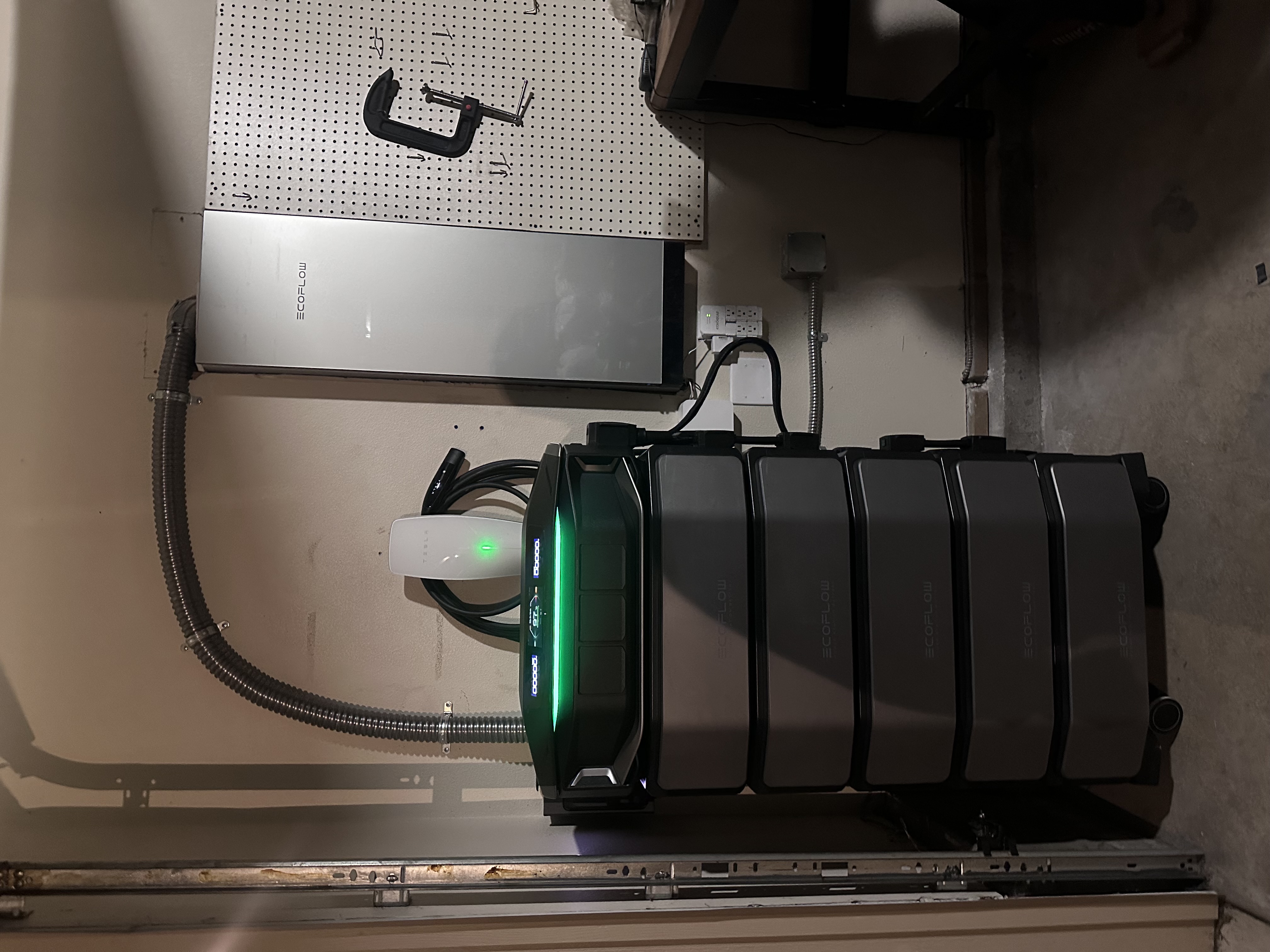 EcoFlow whole-home battery backup system with stacked battery modules and Tesla EV charger