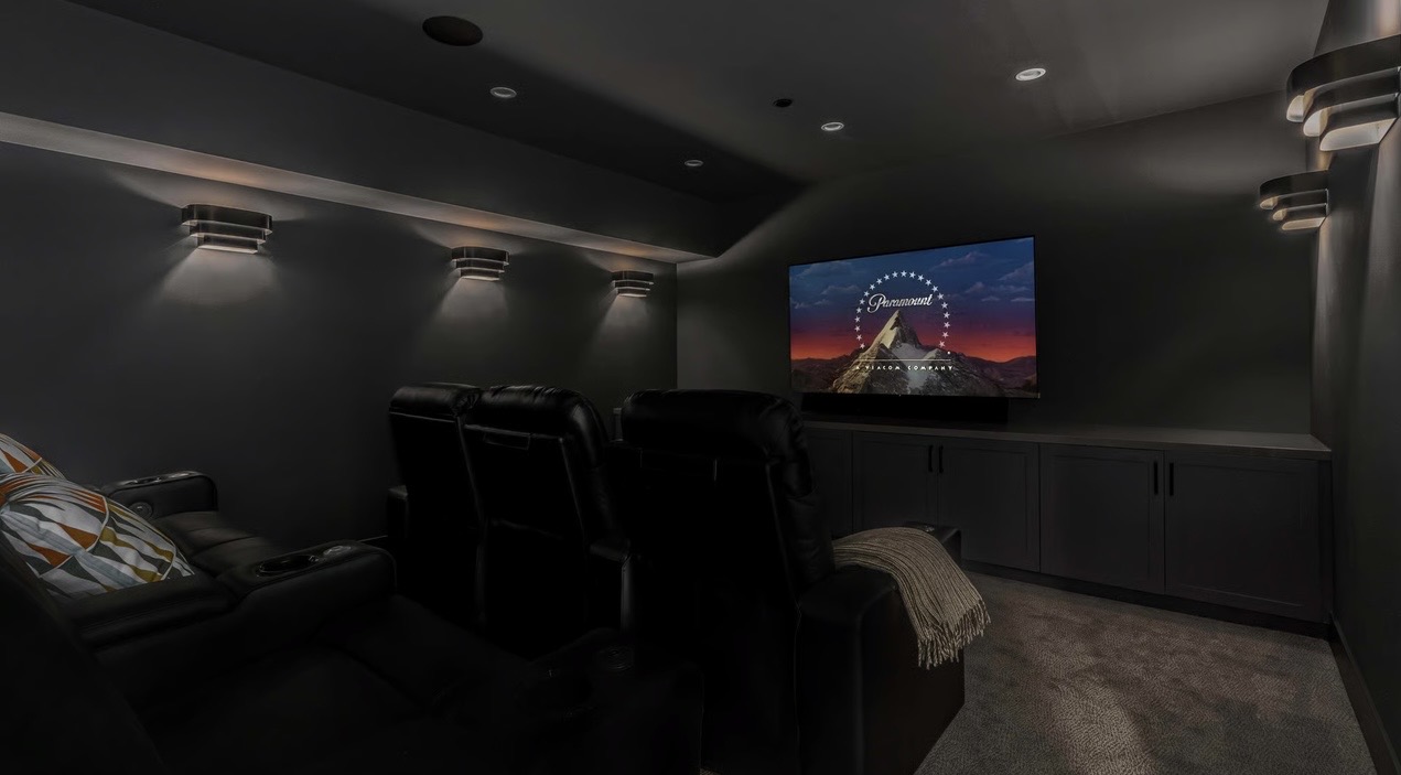 Custom home theater with recessed ceiling lights and modern wall sconces