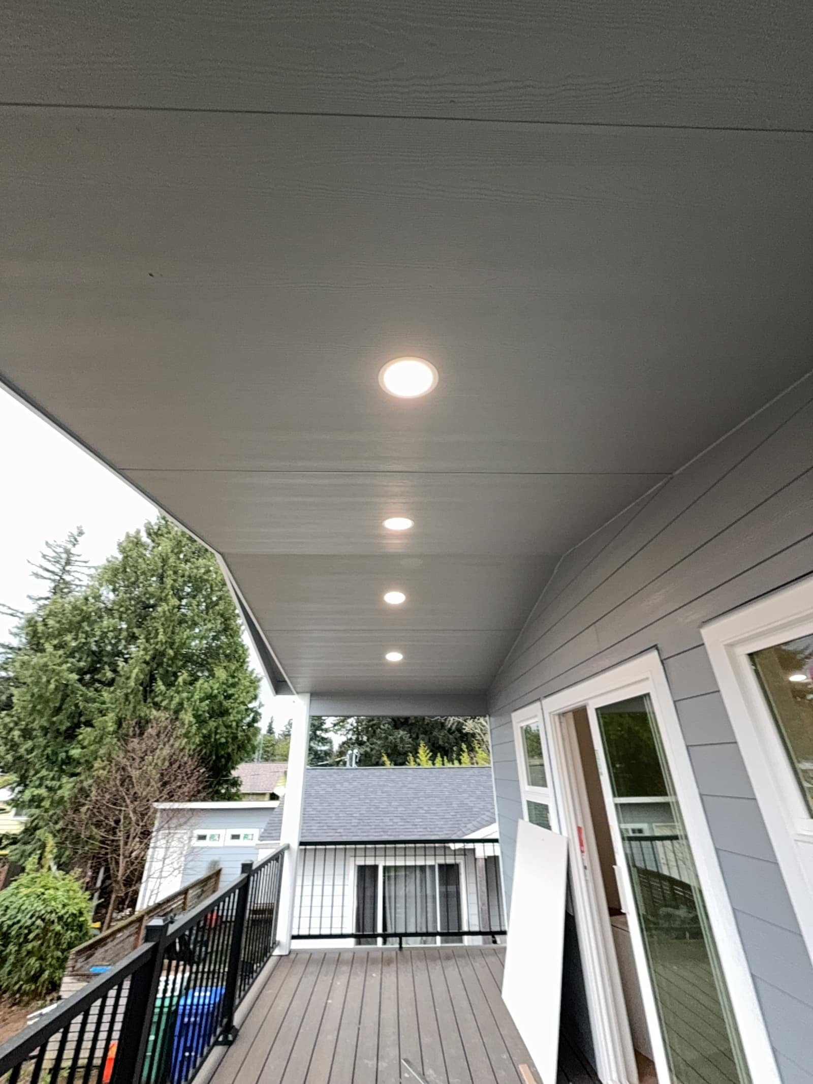 Multiple recessed LED lights installed along the ceiling of a covered patio area.